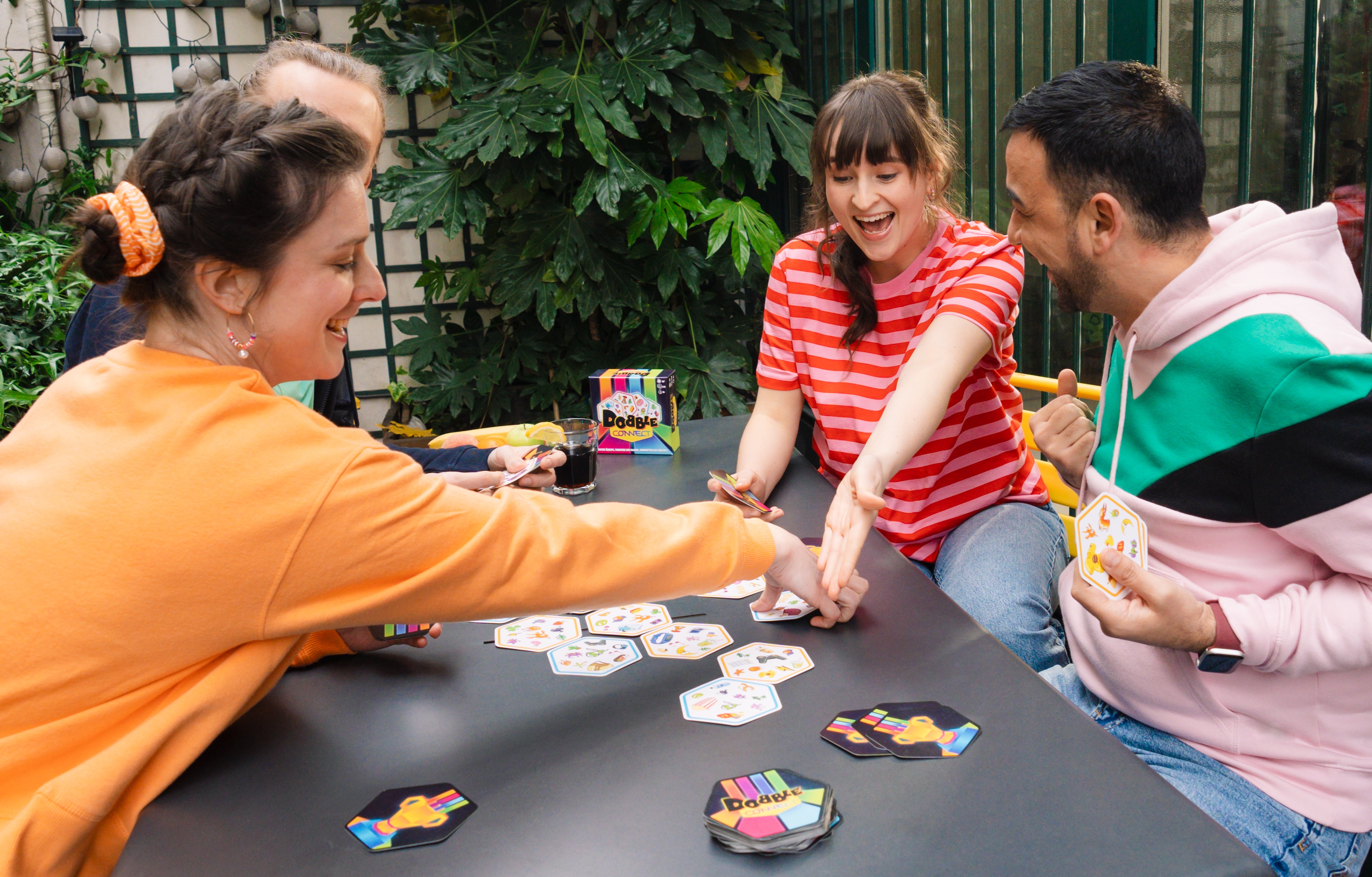 Several adults playing dobble connect and laughing